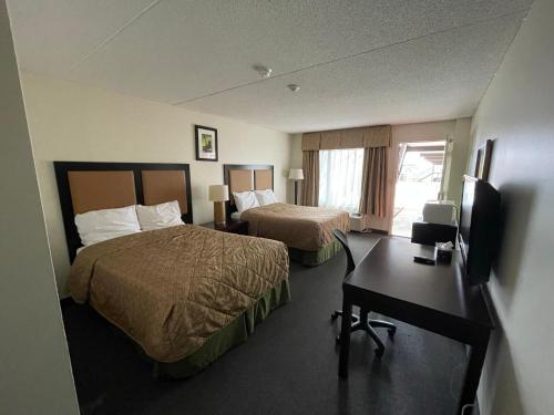尼亚加拉瀑布Heritage Inn & Suites的酒店客房配有两张床和一张书桌