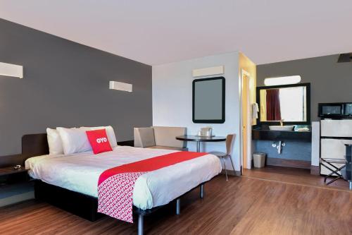 瓦尔多斯塔OYO Hotel Valdosta GA I-75的一间卧室配有一张床、一张桌子和一台电视。