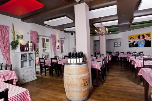 富伦Vakantiewoningen-Pizzeria Blanckthys Voeren的用餐室配有桌椅和酒桶