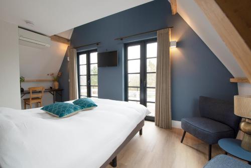 NieuwkoopThe Lake Inn的卧室配有白色的床和蓝色的墙壁