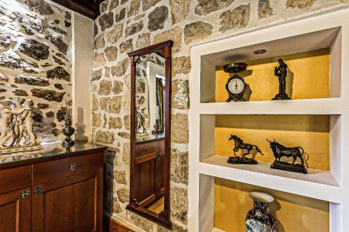 波拉卡Heritage Hotel & Estate Raznjevica Dvori AD 1307的一间设有石墙、架子和镜子的房间