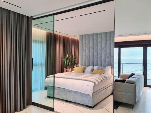 济夫努夫BALTIC VIEW Luxury Apartment Gardenia FRONT的一间卧室设有一张床和玻璃墙