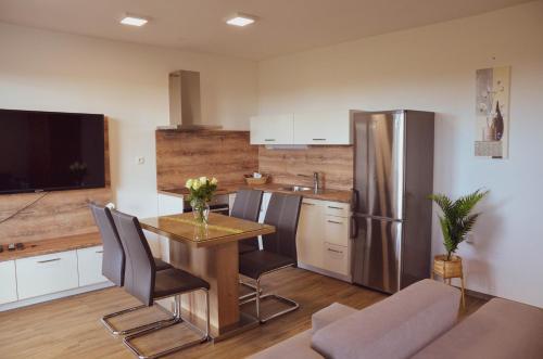 摩拉瓦托普利采Apartmaji Aida的厨房配有桌子和不锈钢冰箱。