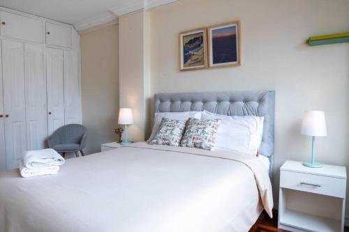 拉巴斯Sky Suites - Spacious Apt in the best area of La Paz的卧室配有一张白色大床和一把椅子