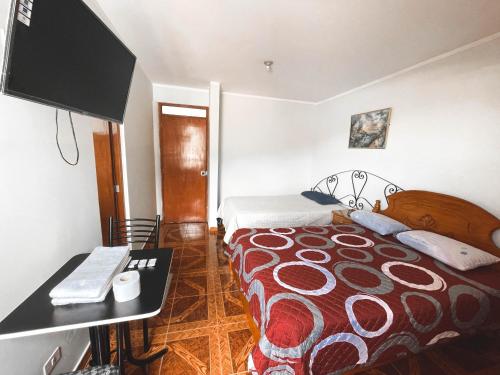 CarazHotel Cordillera Blanca的配有床和书桌的酒店客房