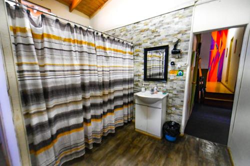 普孔杰科旅舍的一间带水槽和淋浴帘的浴室