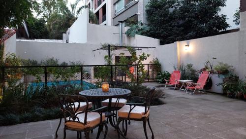 La LucilaRawson 3840 Alquiler de Suites La Lucila, Vicente Lopez, Buenos Aires的一个带桌椅和围栏的庭院