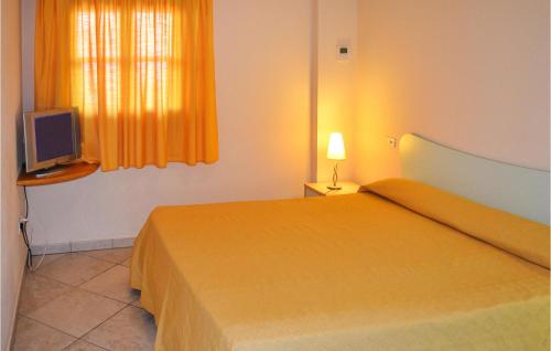 里卡迪Amazing Apartment In Ricadi With Wifi的酒店客房,配有床和电视