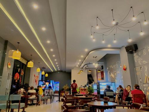 波来古市Phương Trinh Hotel & Coffee的坐在餐厅桌子旁的有吊灯的人