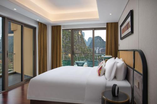 桂林阳朔蔚景温德姆酒店的一间卧室设有一张大床和一个大窗户
