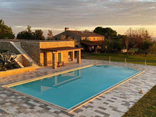 基亚恩尼Belvilla by OYO Podere San Giovanni ventisei的房屋前的游泳池