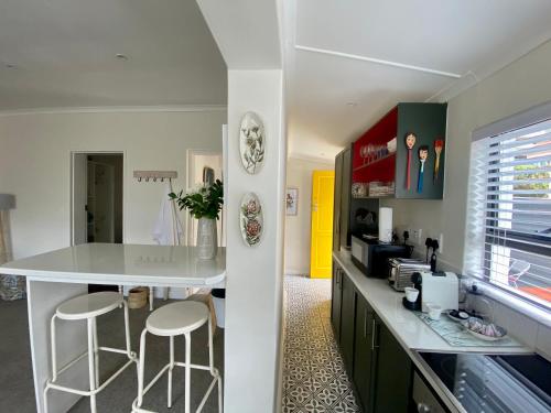 开普敦Walmer Cottage - Cute & Pet friendly的厨房配有白色的柜台和凳子