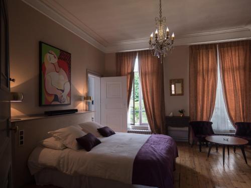 亚眠Une maison en ville, Hyper Centre ville, Spa的一间卧室配有一张床、一张桌子和一个吊灯。