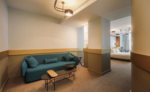 格拉纳达Hotel Colón Centro的客厅配有蓝色的沙发和床。