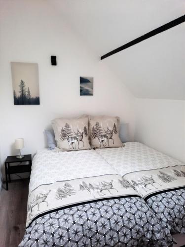 克吕特Gîte L'Equilibre - Lac/montagnes- Familles-groupes的白色卧室配有带白色床单和鹿枕头的床
