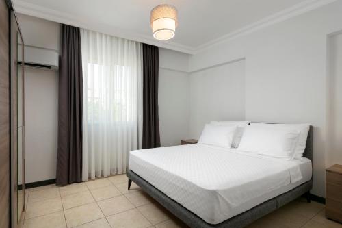 安塔利亚Marvida Happy Suites的卧室配有白色的床和窗户。