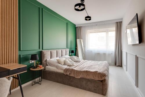 卡托维兹Magic Place - Francuska Park的一间卧室设有绿色的墙壁和一张带枕头的床