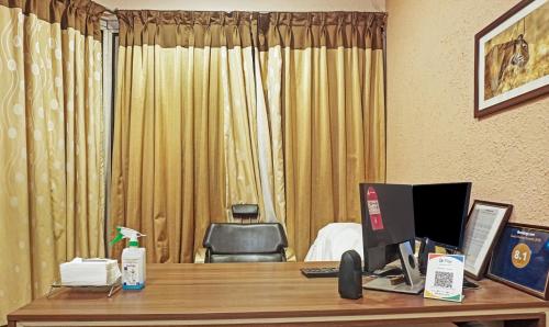 浦那Treebo Trend Excellent Home的酒店客房设有一张书桌和一台电脑