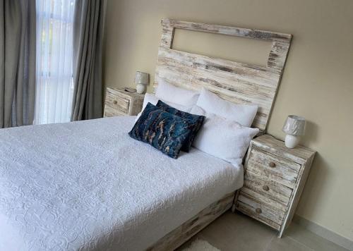 比勒陀利亚Lime Court two的一间卧室配有一张带木制床头板和枕头的床。