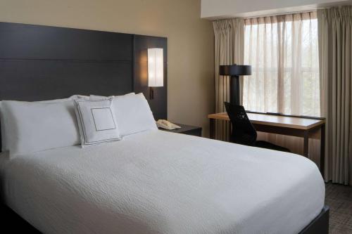 费尔法克斯费尔法克斯费尔拉克斯原住客栈的酒店客房设有一张白色大床和一张书桌