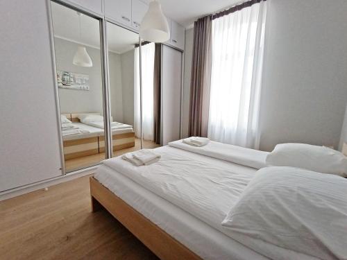 斯维诺乌伊希切Baltic Home Sienkiewicza 5的卧室配有一张白色大床和镜子