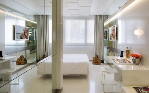 巴塞罗那The Mirror Barcelona Hotel的一间卧室配有一张床、一张书桌和一面镜子