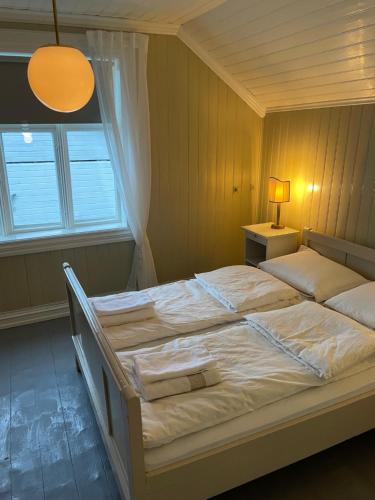 勒丁恩2. etg i Dampskipsbrygga, Lødingen havn的卧室内的一张大床,设有窗户