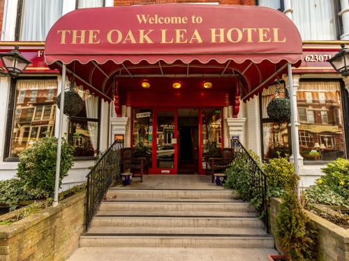 布莱克浦Oak Lea Hotel的红色遮阳篷和楼梯的酒店入口