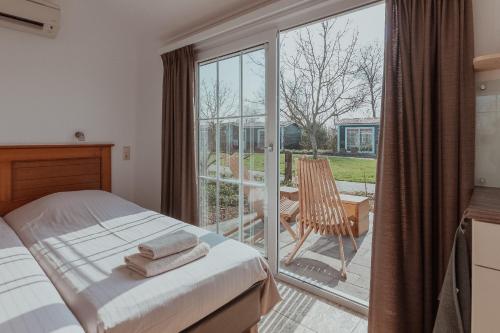东卡佩勒昂斯堡特酒店的一间卧室设有一张床和一个滑动玻璃门