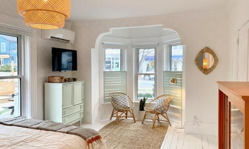 惠灵顿Flats South的一间卧室配有两把椅子和一张床,设有窗户。