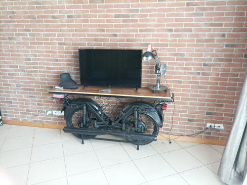 拉齐塞La pacheca的一张桌子,上面有一台电脑,在摩托车的砖墙上