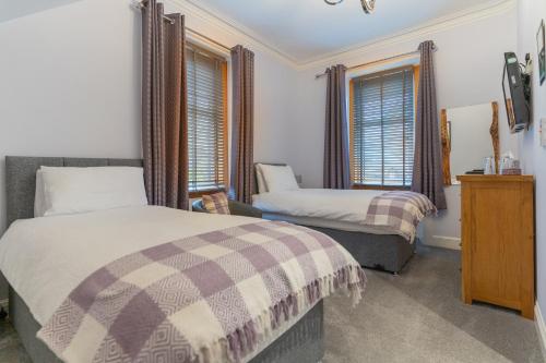 克里夫Galvelbeg House self catering apartment的一间卧室设有两张床和两个窗户。