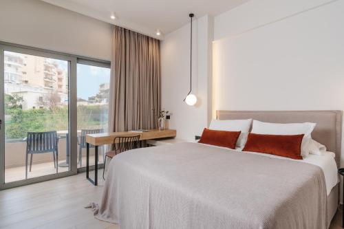 罗希姆诺The City Hotel & Suites的一间卧室配有一张床、一张书桌和一个窗户。