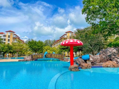 Bandar PenawarTHRE @ Tiara desaru [Private Apartment with Beach]的主题公园的游泳池,带红伞