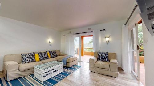 绍斯布鲁姆San Lameer Villa 3002 by Top Destinations Rentals的客厅配有沙发和两把椅子