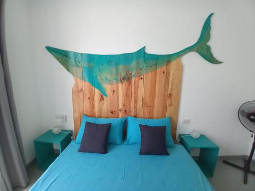 萨尔雷B&B Sereia Azul Boa Vista的一间卧室配有一张蓝色的床和鲸鱼床头板