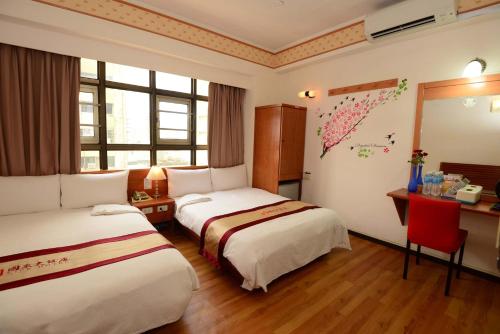 高雄国众大饭店 的酒店客房设有两张床、一张书桌和窗户。