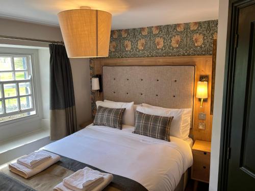 彭里斯Queens Head Inn, Tirril的卧室配有一张带两个枕头的大白色床