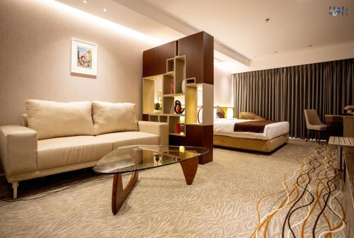 达卡Pearl Hotel的酒店客房设有一张沙发和一张床