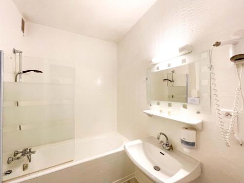 卡纳克阿丽尼蒙酒店的白色的浴室设有水槽、浴缸和水槽。