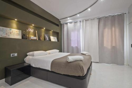 巴塞罗那马蒂公寓的一间卧室配有一张床,上面有两条毛巾