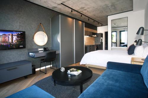 开普敦Bridgewater Apartments by Century City Hotels的一间卧室配有一张床和一张蓝色的沙发