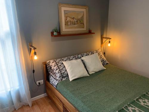 圣萨尔瓦多德朱Casa Olavarria的一间小卧室,配有一张带两个灯的床