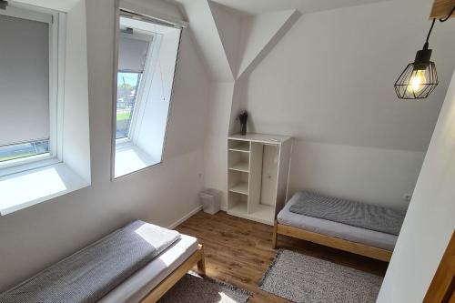 福纽德Mihelyünk的一间白色的小房间,配有床和两个窗户
