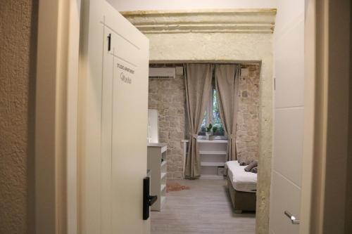 特罗吉尔Studios Kadena Trogir - 18th century stone house的走廊上设有一张床和一个窗口