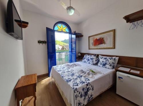 康赛瓦托利亚Pousada do Vovô Luiz的一间卧室配有一张带蓝色门和窗户的床
