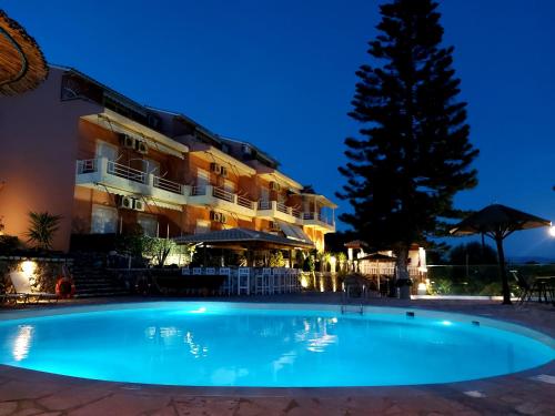 巴尔巴蒂Stefanosplace ApartHotel Sea View的夜间在酒店前的游泳池