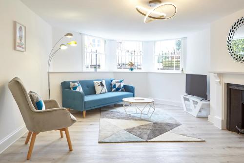 布里斯托Stylish, spacious flat with private parking的客厅配有蓝色的沙发和电视