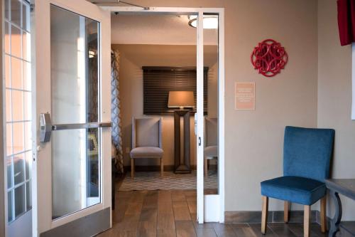克利尔沃特Sonesta Simply Suites Clearwater的走廊上的房间配有桌子和两把椅子
