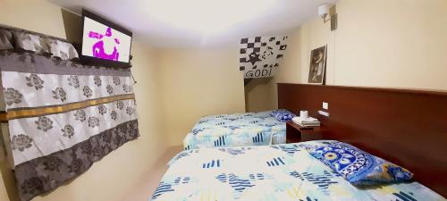 克萨尔特南戈Hotel Ideal, Your House in Quetzaltenango的一间卧室设有两张单人床和一台电视机。